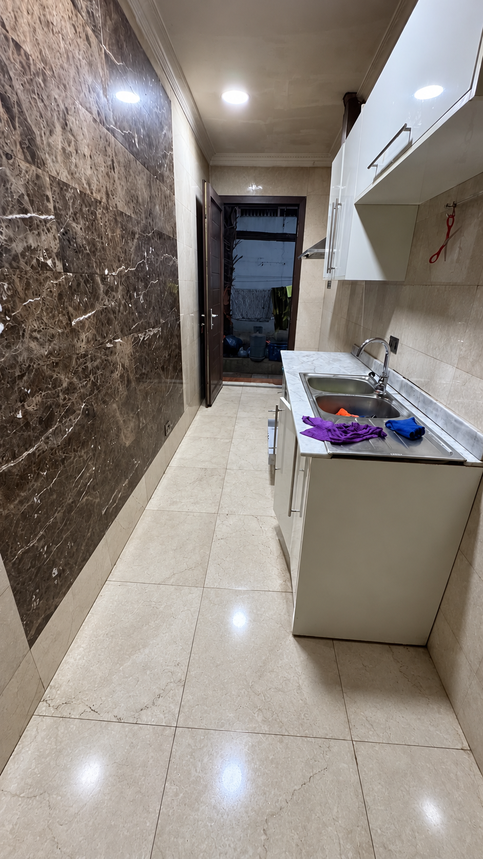 Kitchen work area with tiled surfaces and sink; floor digitally retouched